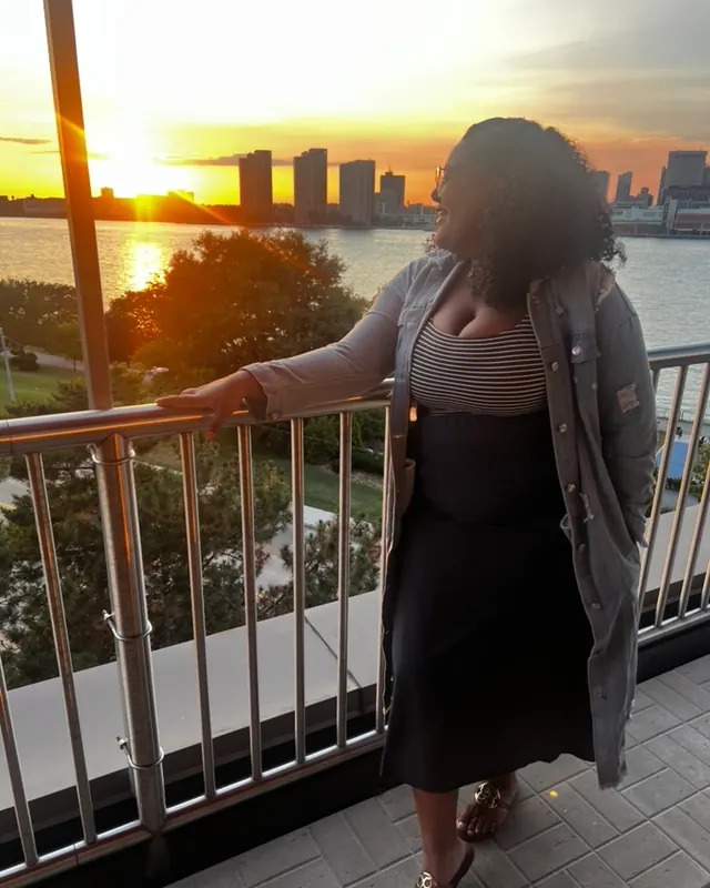 Kendra watching the sunset over the river skyline
